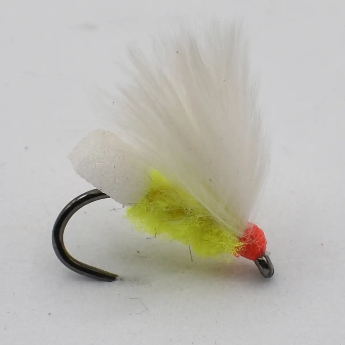 White feather-winged fishing fly with neon yellow body and orange bead on a black hook, close-up for anglers