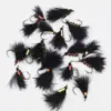 Assorted black feather fishing flies with colorful bead heads and sharp hooks laid on a white background.