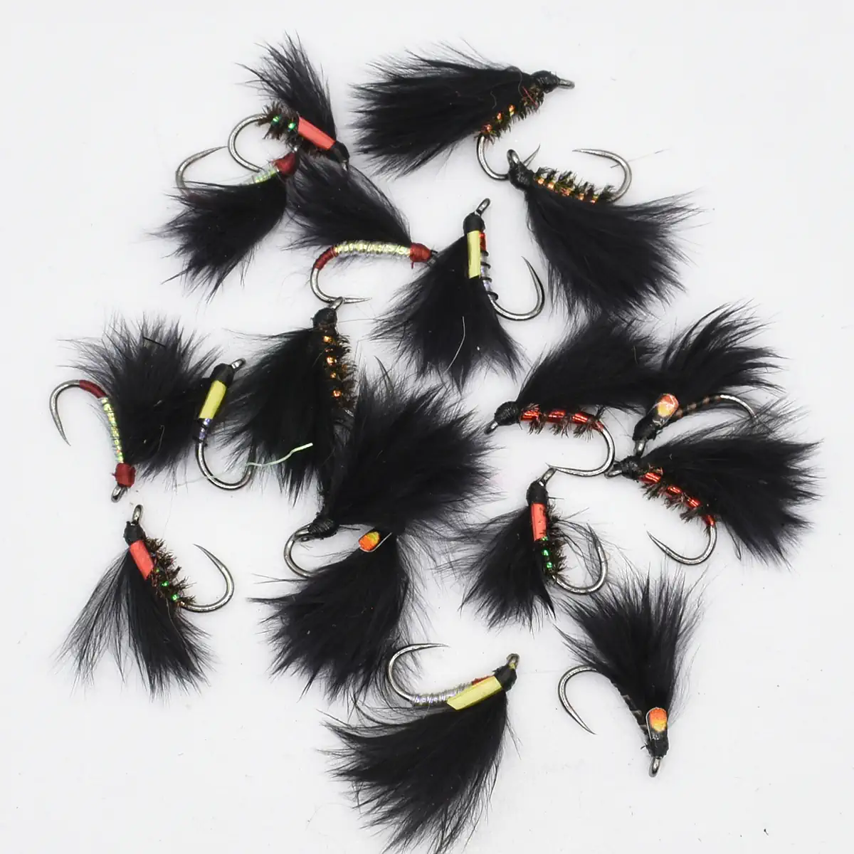 Assorted black feather fishing flies with colorful bead heads and sharp hooks laid on a white background.