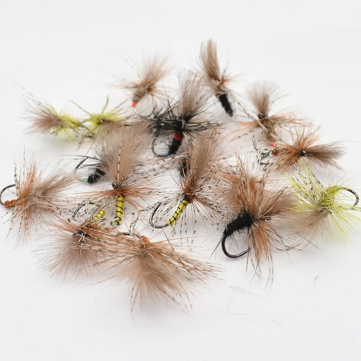 Assorted fluffy fishing flies with brown hackle and colorful bodies on a white background.