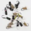 Assorted fly fishing flies with black, white, and yellow fuzzy bodies and hooked metal hooks on a white background.