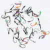 Assortment of colorful fishing flies with hooks scattered on a white background, for fly fishing gear.