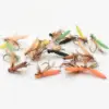 Assorted color fishing flies with feathery bodies laid on a white background, ready for fly fishing gear.