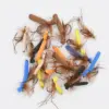 Assortment of colorful fly fishing lures with foam bodies in orange, yellow, and blue, and brown feather tails with hooks.