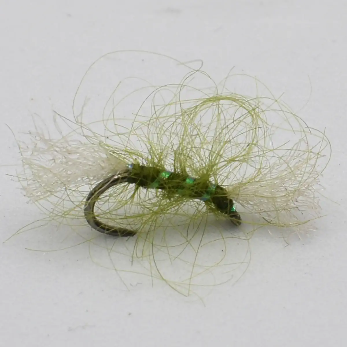 Green-haired fishing lure tied to a curved hook, used for fly fishing.