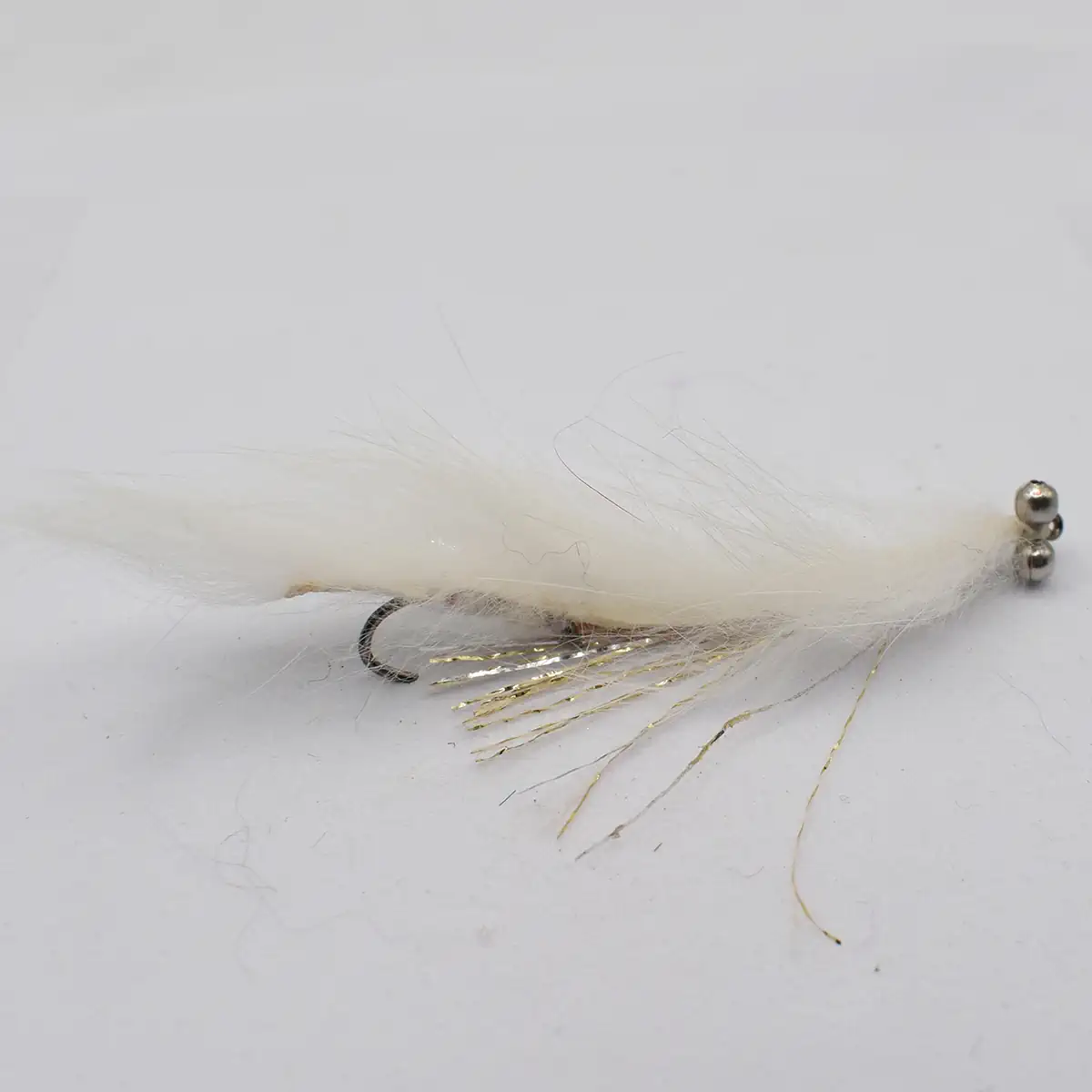 White fluffy fishing fly with a bead head and metallic tinsel strands, used as a lure for freshwater fishing.