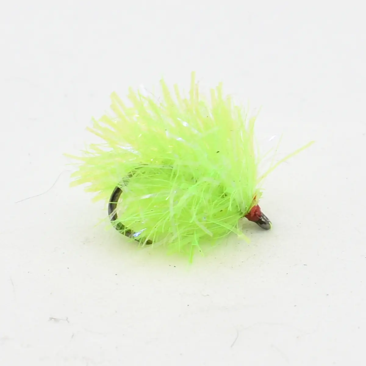 Bright neon green fishing fly with fluffy tinsel and exposed hook, used as a lure for freshwater fishing