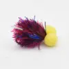 Colorful fishing lure with pink and blue tinsel strands and two yellow foam beads at the end, designed to attract fish