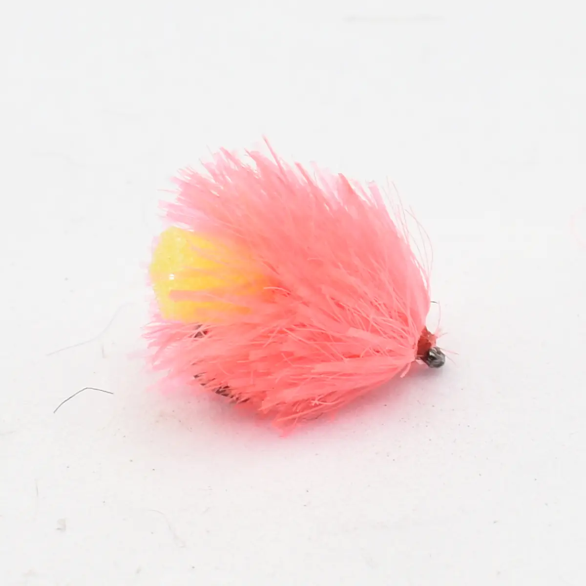 Pink fluffy fishing lure with a yellow underside and small hook at the end.