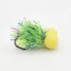 A fishing jig with a green fluffy skirt and yellow bead/foam on a white background, used to attract fish.
