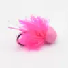 Pink fluffy fishing lure with a pom-pom and iridescent strands on a metal ring, laid on a white background