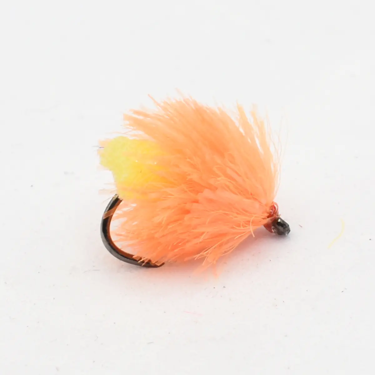 Orange fluffy fishing fly with a curved hook, used as a lure in fishing