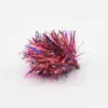 Colorful tinsel fishing lure with pink, red, blue metallic strands on a small jig head ready to cast