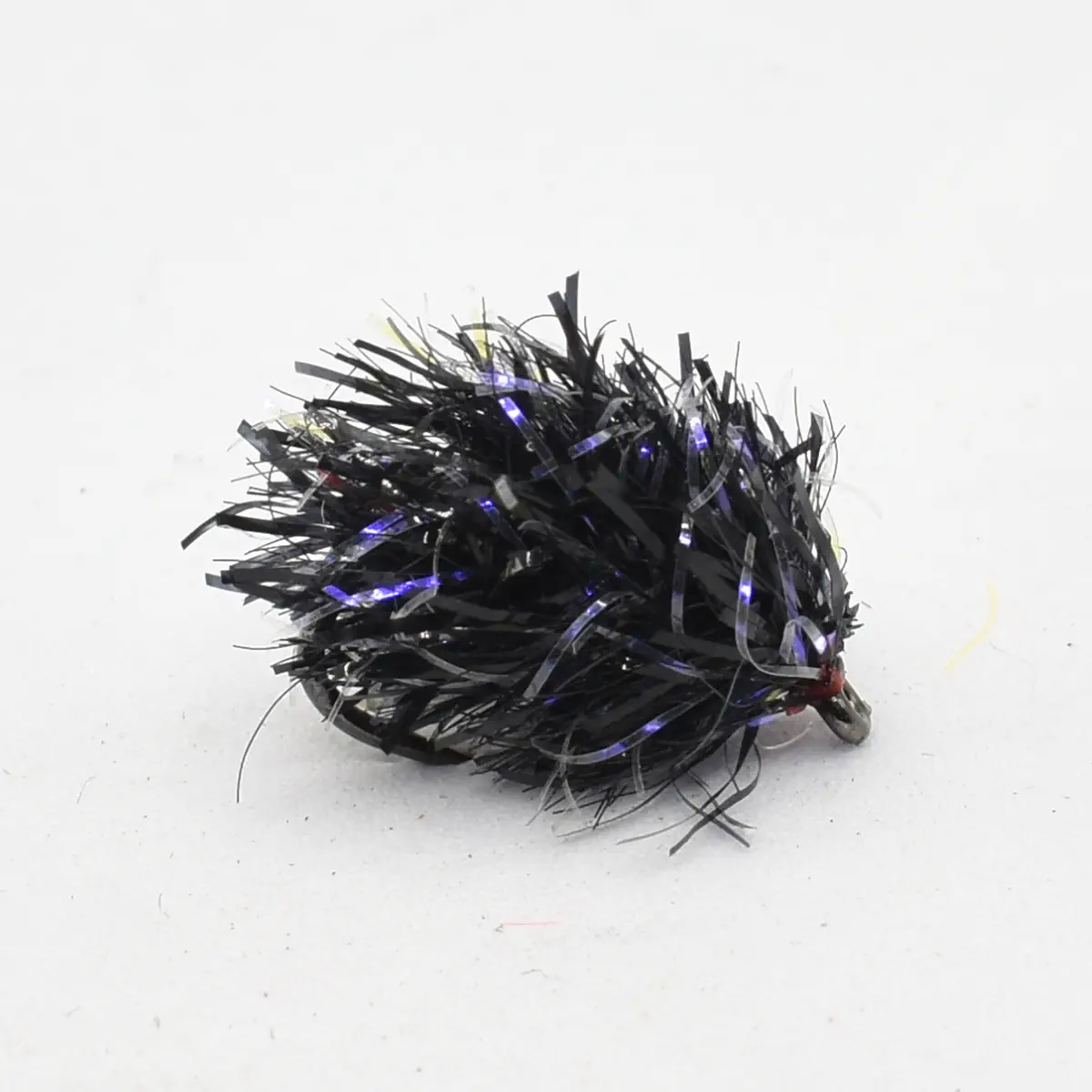 Black tinsel fishing jig with purple-tinged strands and a small hook at one end.