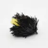 Black bristle fishing lure with a small yellow tail, viewed from the side in a white background, used for bass fishing