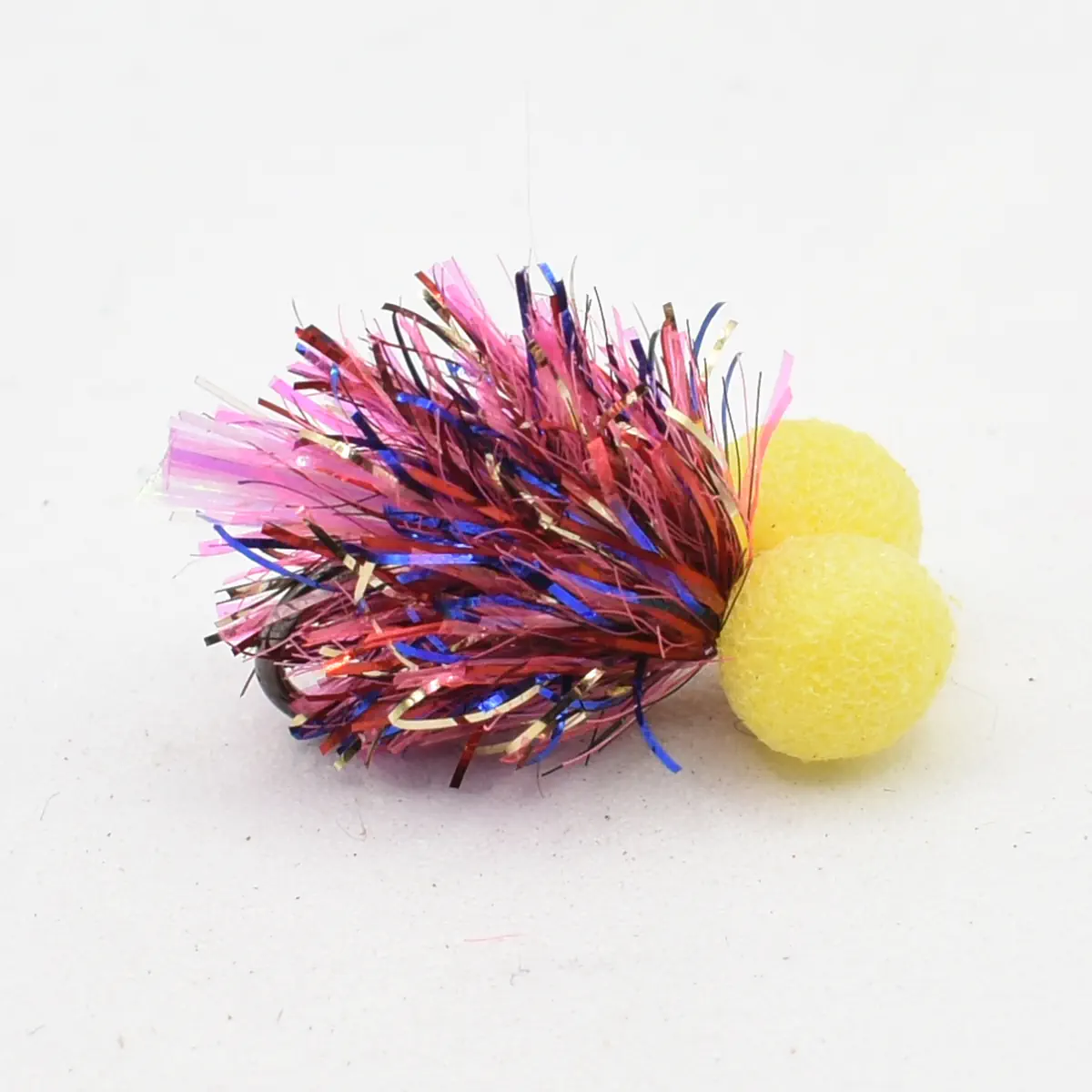Colorful tinsel pom-pom cat toy with two yellow foam balls attached on a white background.