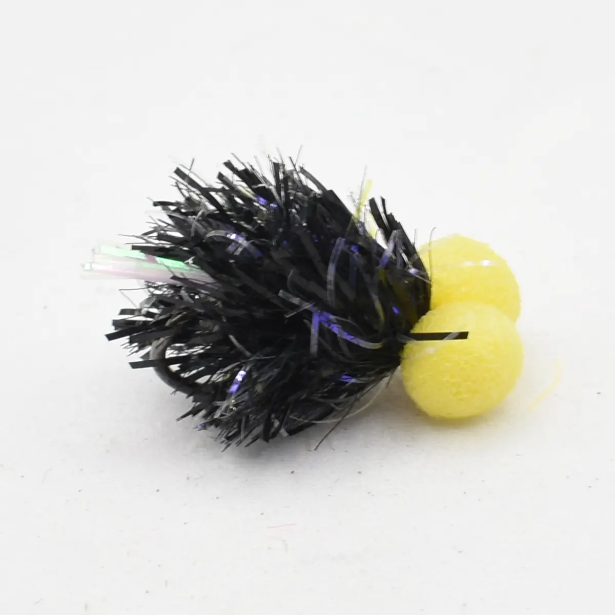 Small craft decoration: a black metallic tinsel pom-pom with two yellow foam balls attached.