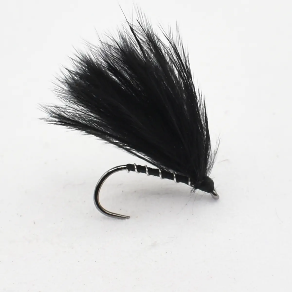 Black artificial fly fishing lure with a fluffy feather hackle tied to a curved hook, used for fly fishing