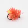 Bright pink and orange fluffy fishing lure with a black hook visible in the background