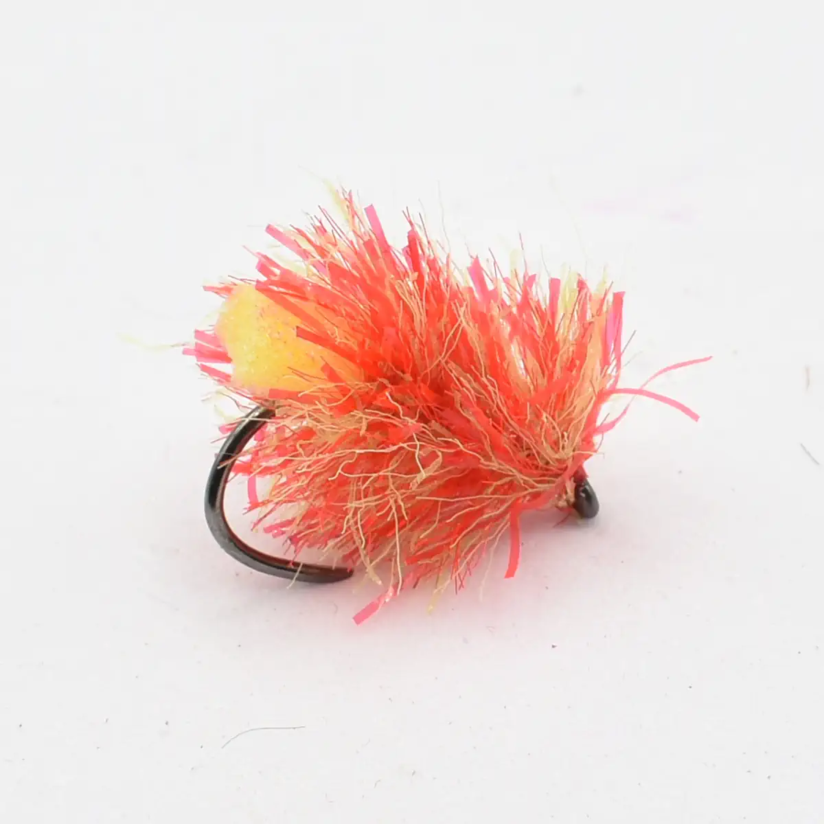 Bright pink and orange fluffy fishing lure with a black hook visible in the background