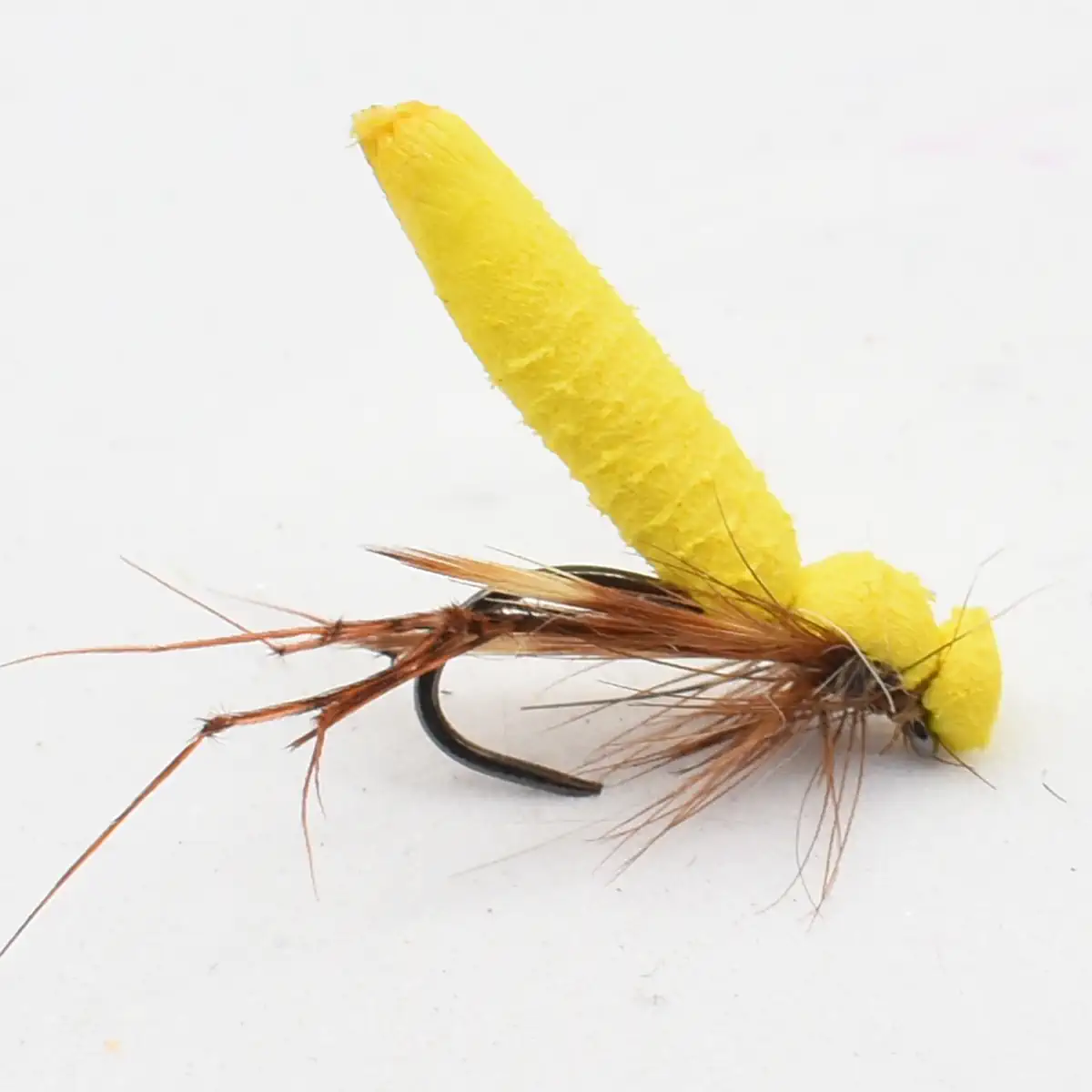 Yellow foam-bodied fishing fly with brown feather tail on a curved hook, used for fly fishing.