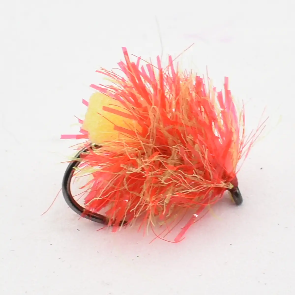 Bright orange fluffy fishing lure with a black curved hook attached to it