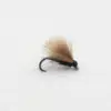 A tan, fluffy fishing fly with a black body on a small curved hook, used for fly fishing.