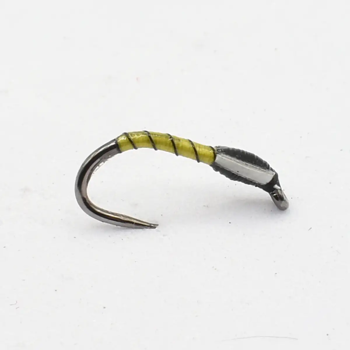 Yellow-wrapped fishing fly on a curved hook, close-up lure used for trout fishing