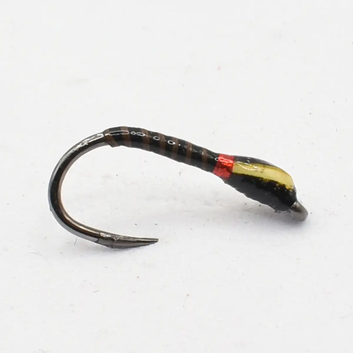 Small fishing lure: a curved hook with a black body and a yellow-red painted head.