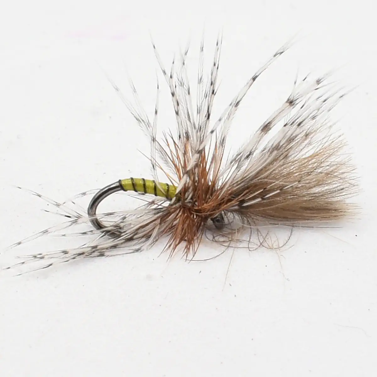 Brown and tan fishing fly with fluffy tail feathers on a hooked body