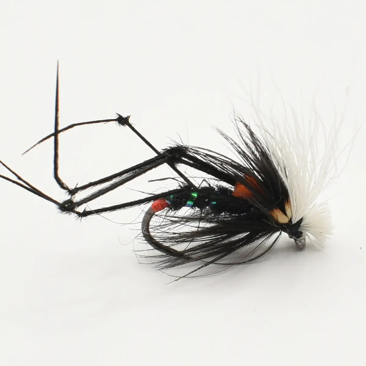 Close-up of a black fishing fly lure with white feather hackle used for trout fishing