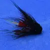 Close-up of a fishing fly lure with a red body and black feathered hackle on a blue background mainly used for fly fishing the fish.