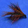 Artificial fishing fly with brown and green hackle on a blue background, used as a lure for fly fishing.