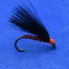 Red-bodied fishing fly with black feather hackle on a curved hook against a blue background, a classic lure for fly fishing.