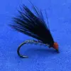 Close-up of a black feathered fishing fly with a red head tied to a curved hook on a blue background.