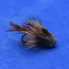 Artificial fly fishing lure with brown and tan feather fibers on a curved hook resting on a blue surface