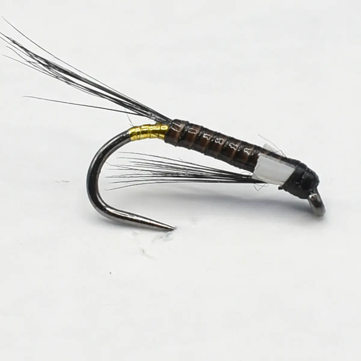Close-up of a brown segmented fishing fly with a curved hook and wispy black tail fibers, featuring gold ribbing.