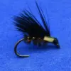 Black feathered fishing fly with a pale green body on a curved hook against a blue background.