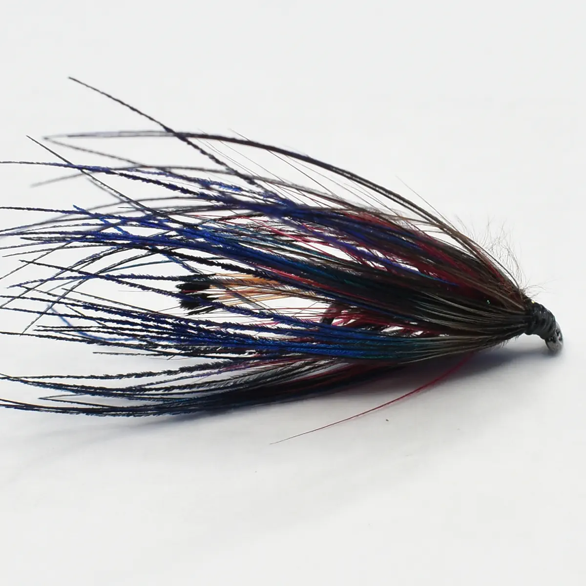 Colorful fishing lure with long blue, black, and red strands on a dark weighted head.