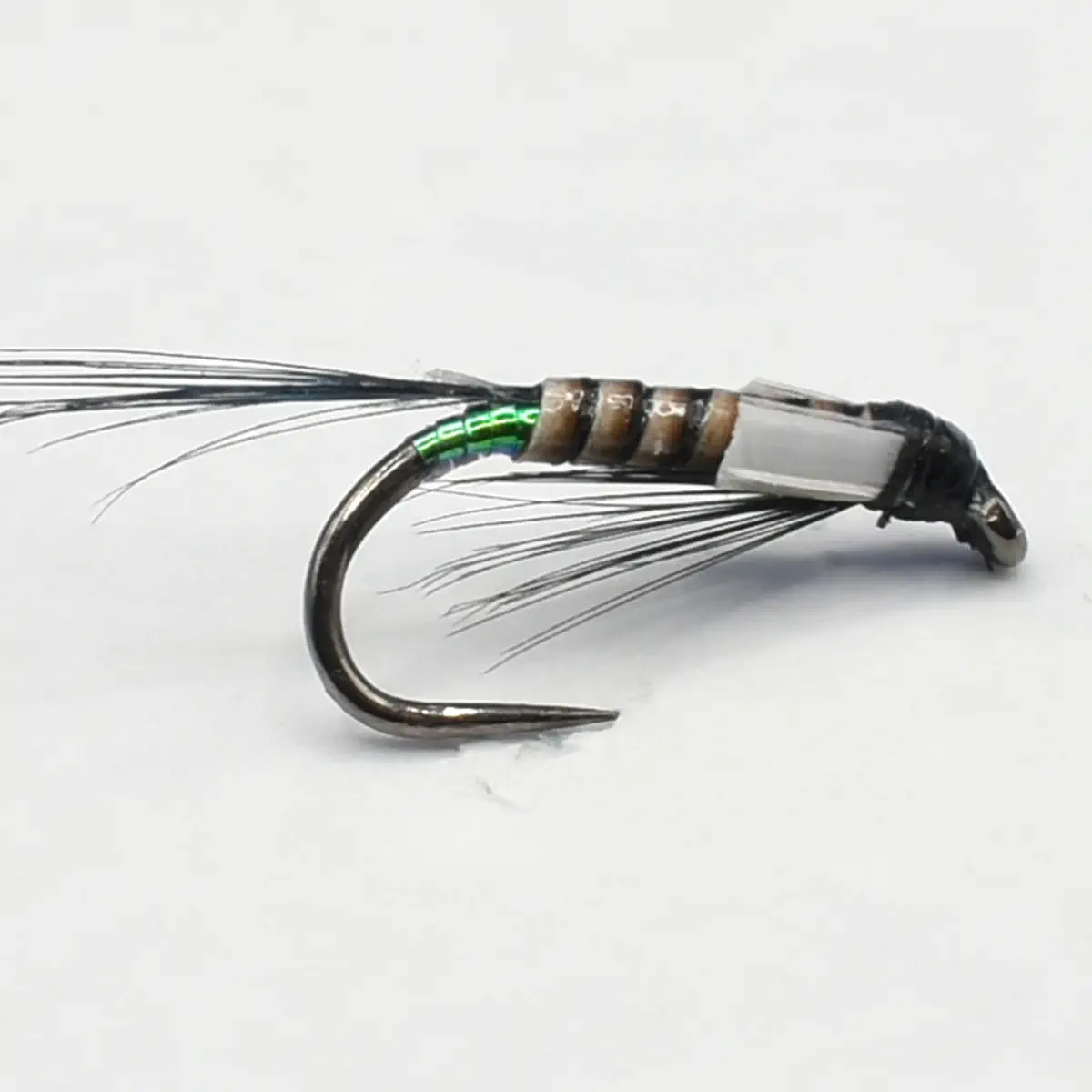 A fly fishing lure tied on a curved hook with green bead wraps and wispy black feather hackle used to imitate prey.