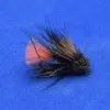 Close-up of a black-and-brown fishing fly with an orange tail on a blue background.