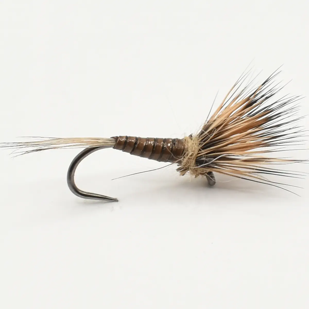 Close-up of a brown and tan fishing fly tied to a hook, with feather hackle and thread-wrapped body.