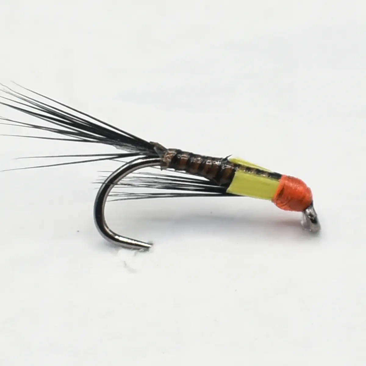 Bead-head fishing fly with yellow body, orange head, and long black tail feathers on a hook.