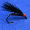 Red-bodied black streamer fishing fly with long black hackle tied to a curved hook, set on a blue background, used for fly fishing