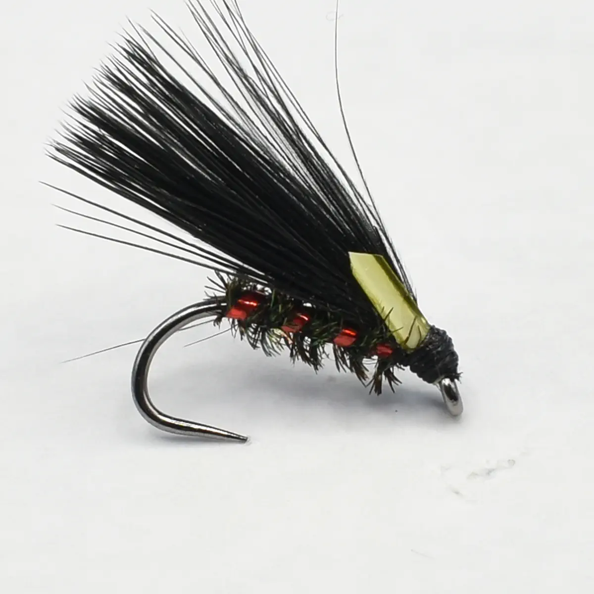 Fly fishing lure with long black hackle, red bead ribbing, and a yellow body.