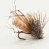 Close-up of a fishing fly lure with a curved hook, tan fluffy body, and a tuft of gray-brown hackle feathers.