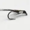 Close-up of a black fishing fly lure with bead-wrapped body and curved hook.