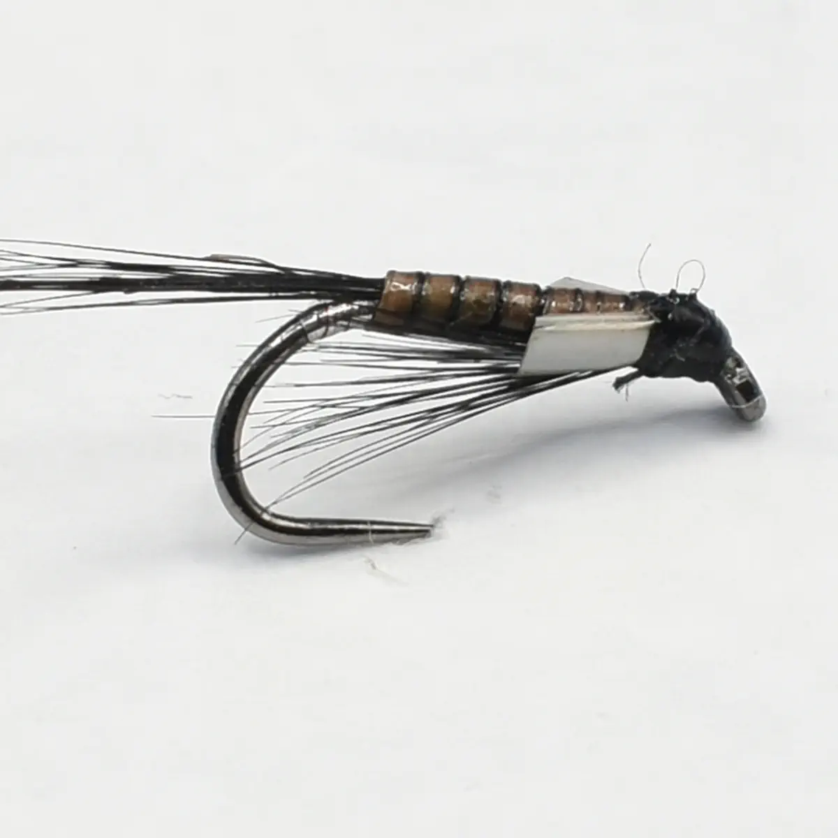 Close-up of a black fishing fly lure with bead-wrapped body and curved hook.