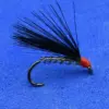 Artificial fishing fly: black hackle tail tied to a hook with red head, used as bait for fly fishing