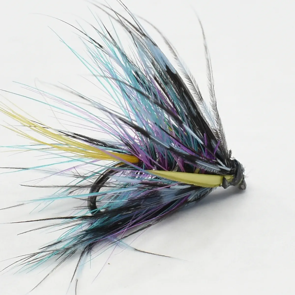 Colorful fly fishing lure with multicolored feather fibers tied to a curved hook, arranged like a fan.